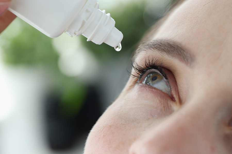 Woman using eyedrops to reduce red eye