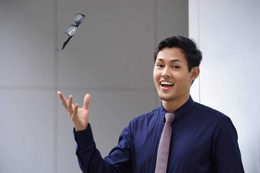 Young man throwing away glasses after refractive surgery